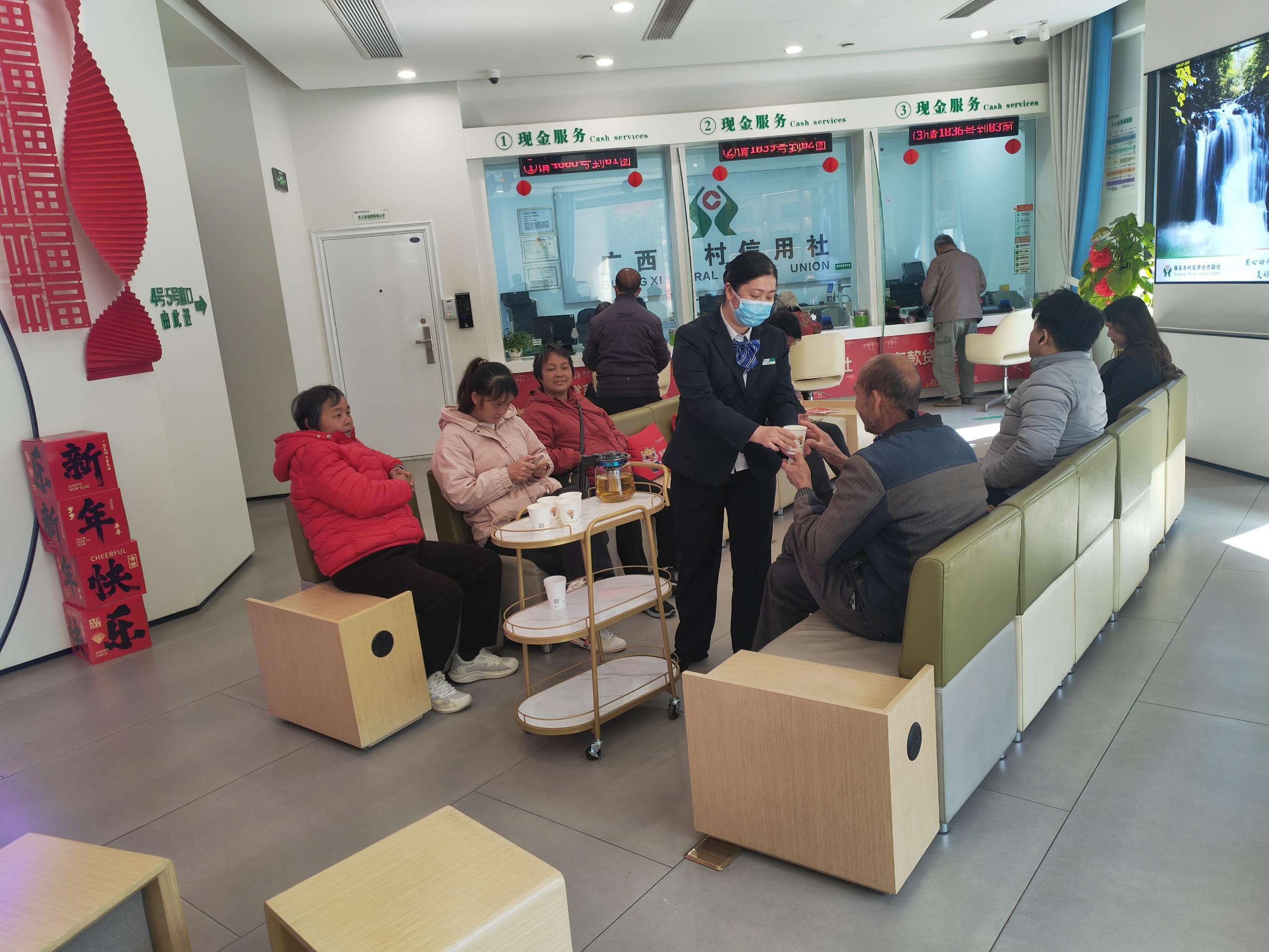 藤縣農(nóng)村信用合作聯(lián)社工作人員手捧熱茶遞送給前來辦理業(yè)務(wù)的群眾 藤縣農(nóng)村信用合作聯(lián)社供圖